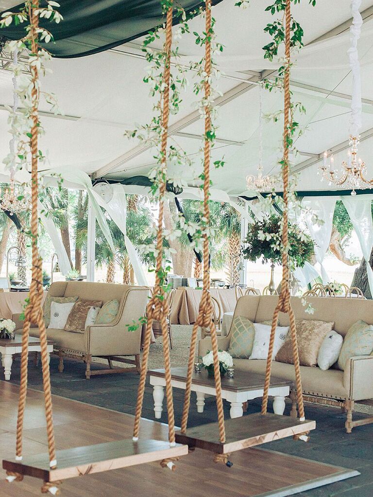 Whimsical rope swings with green vines in wedding tent