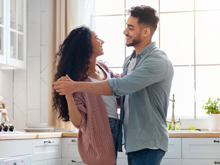 Couple in a committed relationship dancing in the kitchen.