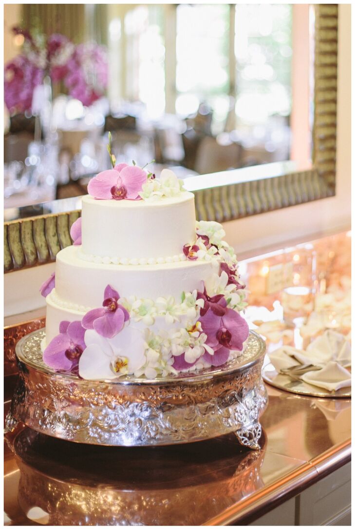 The White 3 Tier Cake Decorated With Purple And White Flowers