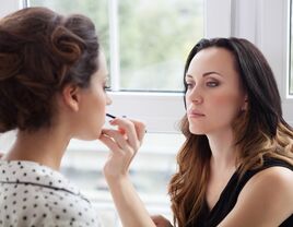 woman getting professional makeup done by makeup artist