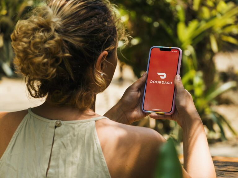 Woman looks at Doordash app on her phone thank-you gift