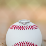 Engagement ring sitting on top of a baseball