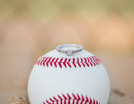 Engagement ring sitting on top of a baseball