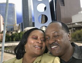 A couple on a ferris wheel with the Houston skyline behind them.