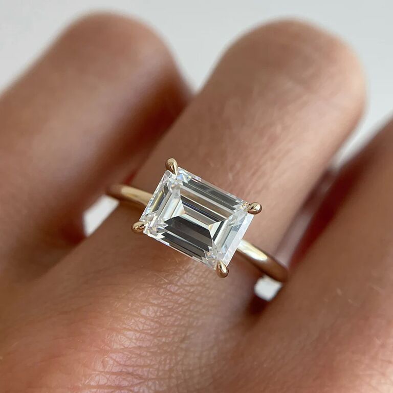 elegant east-west emerald diamond with simple gold band