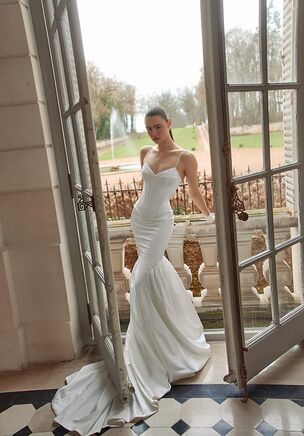Satin and lace unite to define Lior from the Maison Blanche collection by WONÃ Concept. Pearls and beading introduce texture to the sculpted bodice. A curved, dipping neckline balances the fitted silhouette, flowing into a low V back. Hugging the natural waist, the gown flares below the hips into a sweeping chapel length train. Transformable, integrating matching glove accessories mirroring the pearl and beaded motifs. Every line of the gown catches the light.