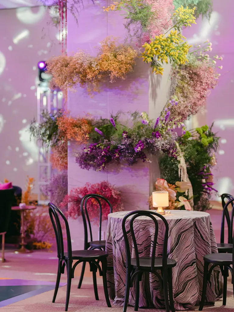 Reception venue with colorful flowers and purple lighting, taylor swift themed wedding 