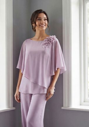 Fresh and fashion-forward, this Jade Chiffon two-piece pant suit is a chic and modern option for the Mother of the Bride. The boat neckline top features a relaxed, flowy fit with an angled ruffle design, accented by a beaded flower at the shoulder for a touch of sparkle. Lightweight and graceful, this ensemble offers effortless movement and style while delivering a confident, contemporary look that feels both elegant and celebratory.