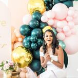 Bride sitting in front of teal-and-pink balloon installation