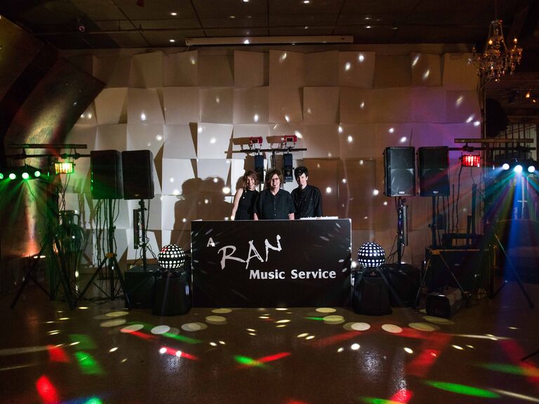 DJs working at the booth with colorful uplighting