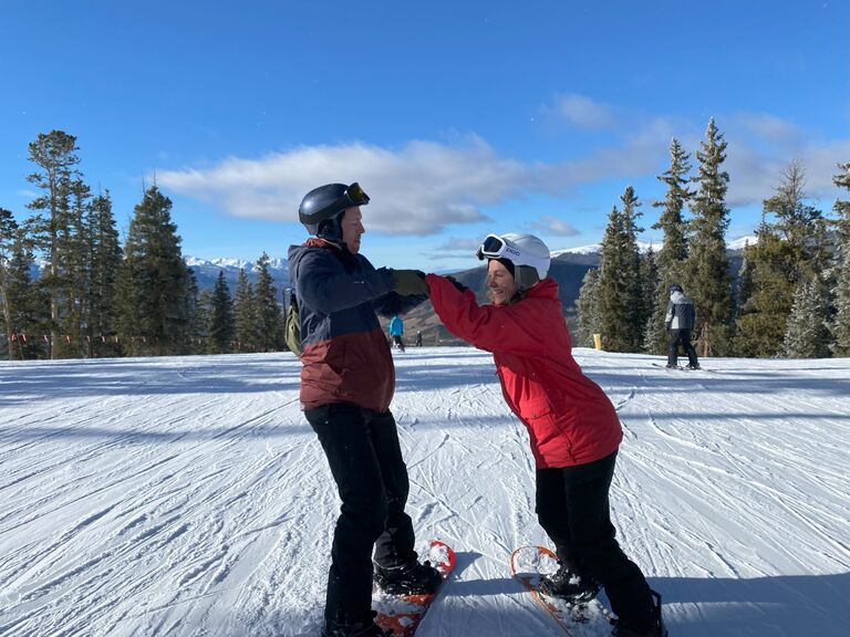 Tom teaches Hallie how to Snowboard