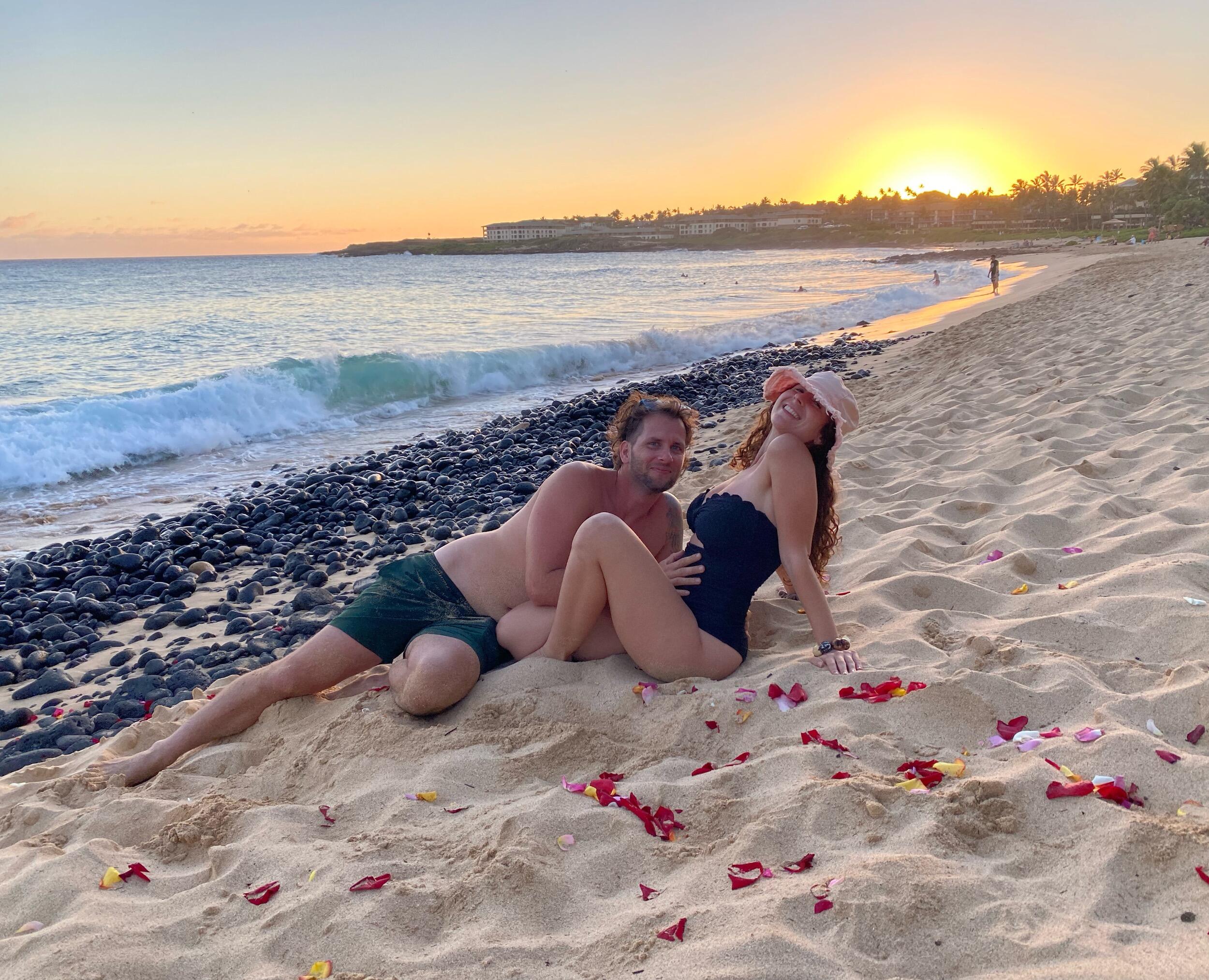 Chris and Jenna enjoy the leftover rose petals from a wedding ceremony at Shipwrecks Beach, while Jenna is 2.5 months pregnant with baby Elliana 
