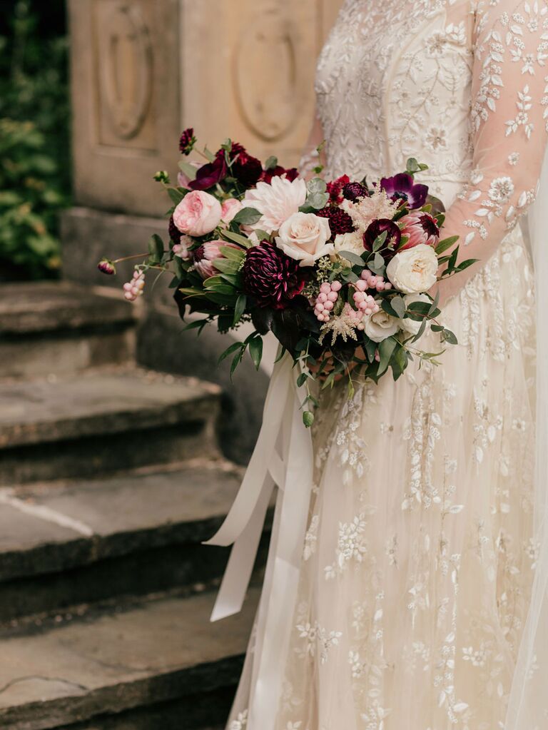 Bride holding fall wedding bouquet with merlot, pink and ivory flowers
