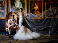 Bride and groom posing in front of vintage art photos