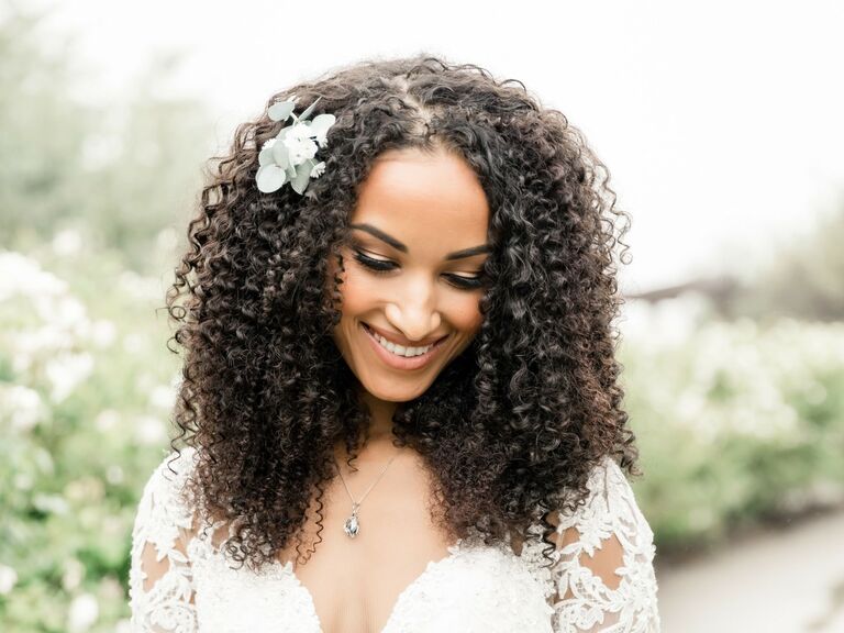 Bride wears her hair in long natural curls. 