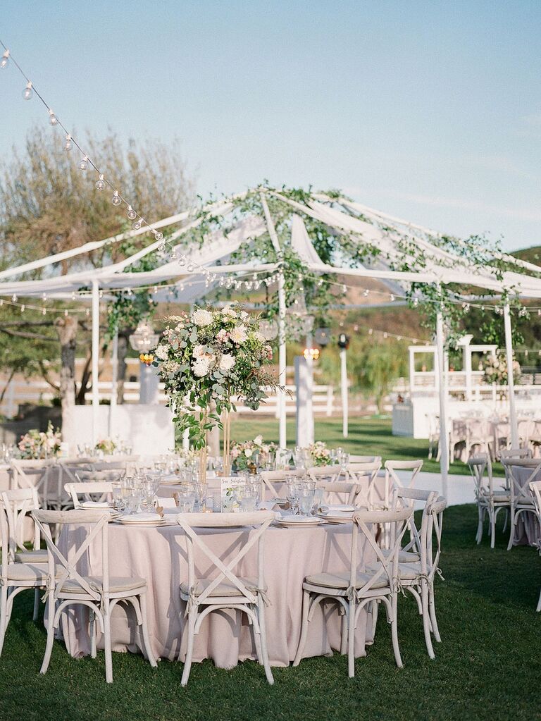 Open-air wedding tent woven with garlands of greenery