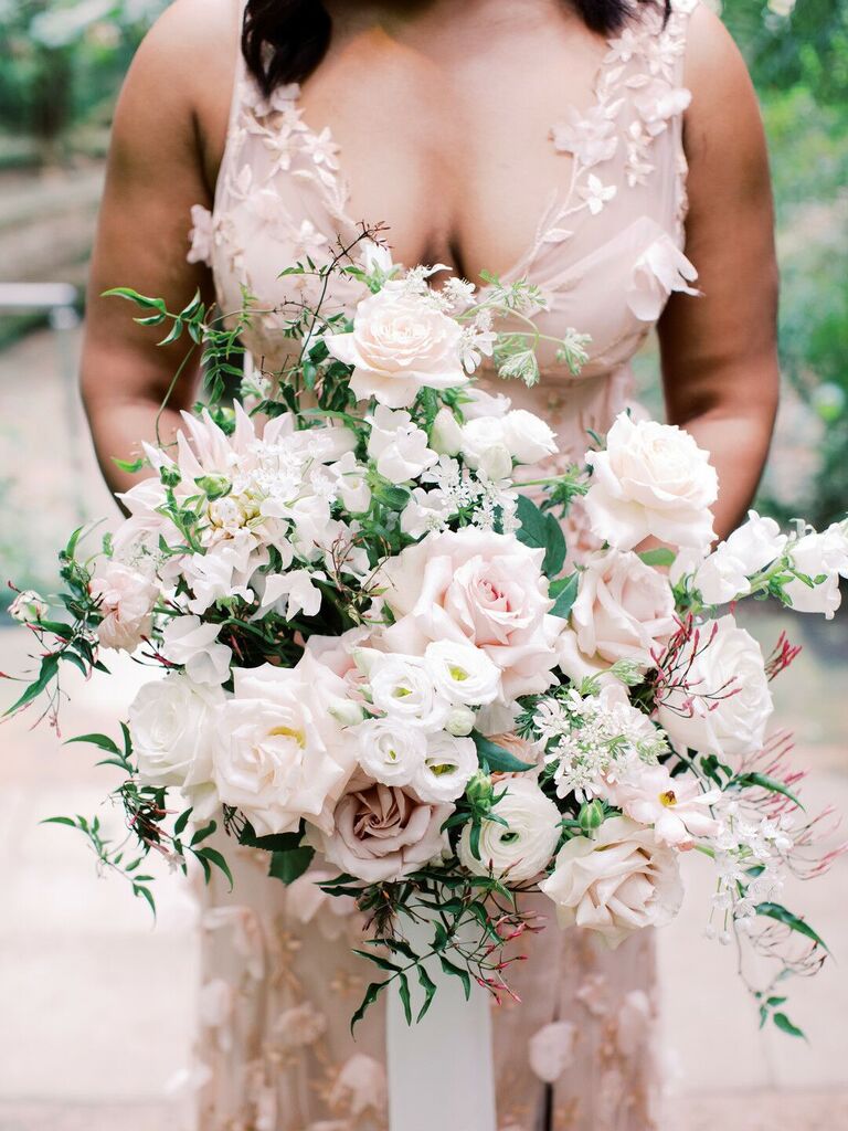 oversized garden style wedding bouquet with blush and ivory roses, jasmine vines, lisianthus, sweet peas and ranunculus