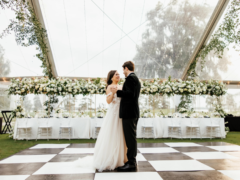 Couple dancing under clear wedding tent rental from Rentaland Tent & Event Rentals