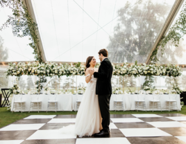 Couple dancing under clear wedding tent rental from Rentaland Tent & Event Rentals