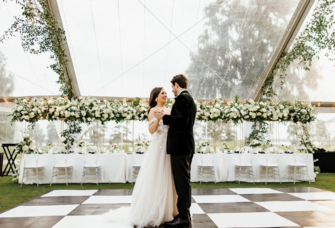 Couple dancing under clear wedding tent rental from Rentaland Tent & Event Rentals