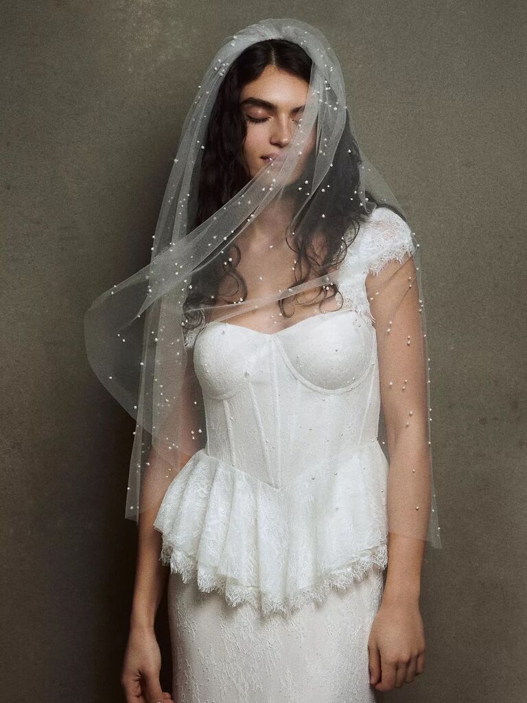 Model wears a beautiful veil embellished with pearls. 