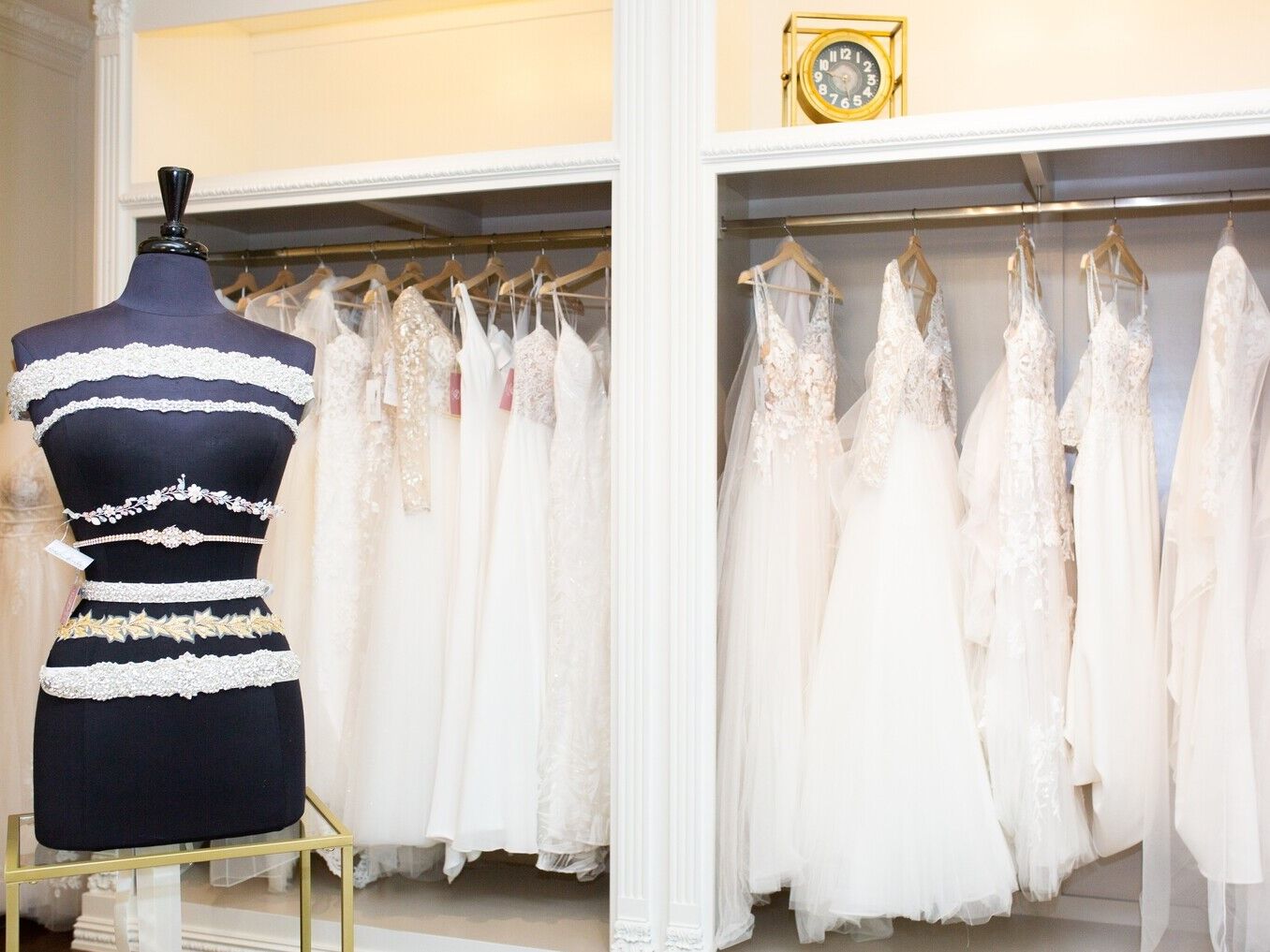 Mannequin in front of a rack of wedding dresses