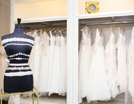 Mannequin in front of a rack of wedding dresses