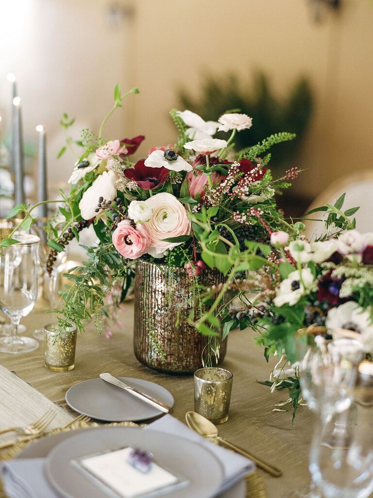 small wedding centerpiece with ranunculus and anemones in mercury glass vase