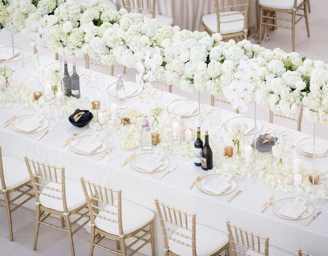 most popular wedding colors aerial view of long formal wedding tablescape with tall white flower centerpieces and gold details