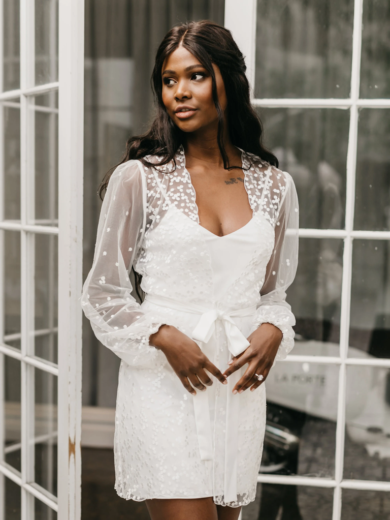 A model shows off this Spot Lace Bridal Robe, with long sleeves and a tie at the natural waist.
