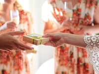 Bride giving bridesmaid gifts in wedding day robes