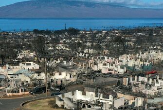 An aerial image shows destroyed homes and vehicles after a wind driven wildfire burned from the hills through neighborhoods to the Pacific Ocean, as seen in the aftermath of the Maui wildfires in Lahaina, Hawaii, on August 17, 2023. Embattled officials in Hawaii who have been criticized for the lack of warnings as a deadly wildfire ripped through a town insisted on August 16 that sounding emergency sirens would not have saved lives. At least 110 people died when the inferno levelled Lahaina last week on the island of Maui, with some residents not aware their town was at risk until they saw flames for themselves. (Photo by Patrick T. Fallon / AFP) 