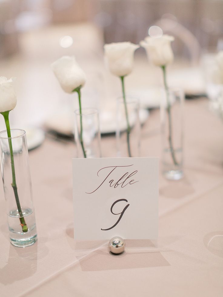 Minimal rose centerpieces and simple black-and-white table number