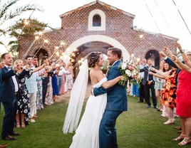 Bride and groom smiling during wedding reception entrance.