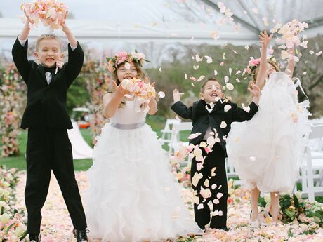Ring bearers and flower girls throwing rose petals