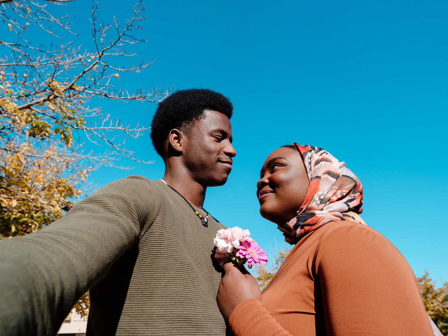 Happy couple looking at each other while taking a selfie