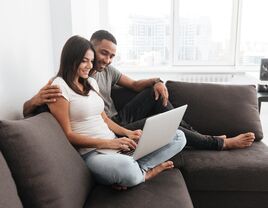 Couple using laptop together at home