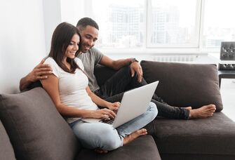 Couple using laptop together at home