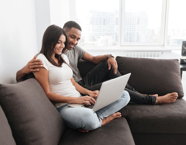 Couple using laptop together at home