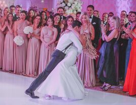 Couple enjoying their first dance while guests watch