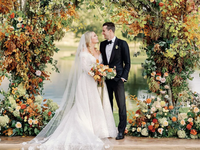 LGBTQ+ couple embracing on rustic lakeside overlook