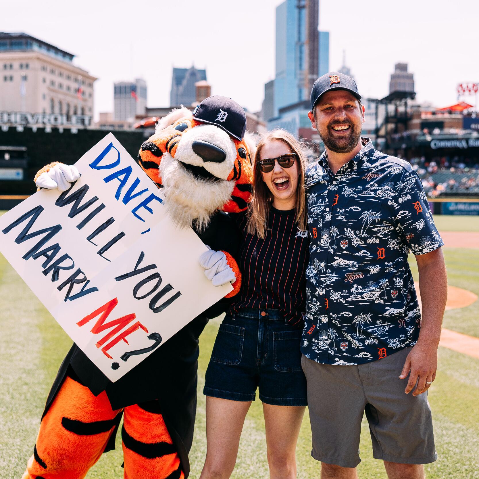 Leah proposed back the next month by arranging for Dave to throw the honorary first pitch at the July 28th Detroit Tigers game and giving him a ring on the field with the help of PAWS the mascot.