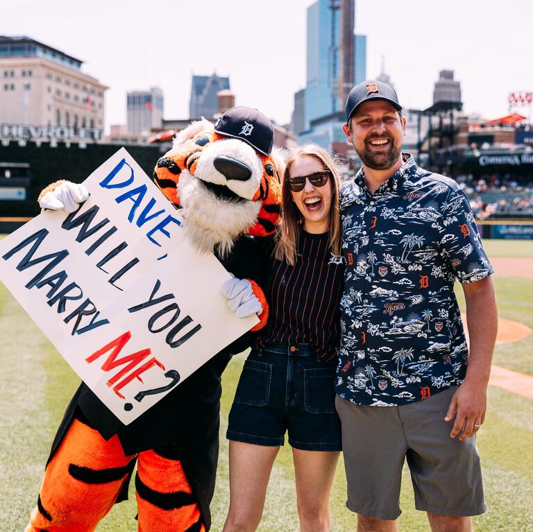 Leah proposed back the next month by arranging for Dave to throw the honorary first pitch at the July 28th Detroit Tigers game and giving him a ring on the field with the help of PAWS the mascot.
