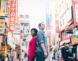 Couple posing back to back on their honeymoon