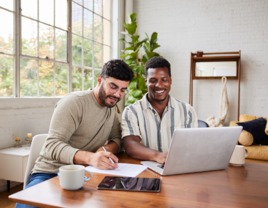 Couple working on their wedding website our story on laptop