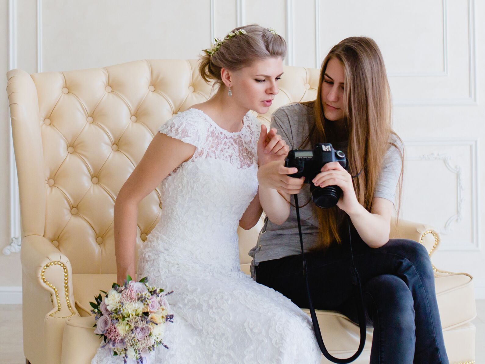 Bride and photographer looking at camera roll