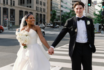 Bride and groom holding hands walking in city