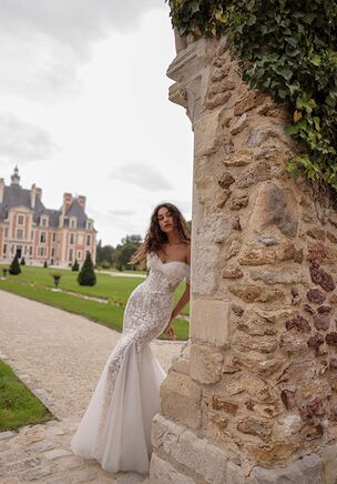 Playful off-the-shoulders mermaid dress with an airy neckline and a fitted bodice flowing into a graceful skirt. The design combines a guipure base with matte floral accents and lightweight mesh to add volume.