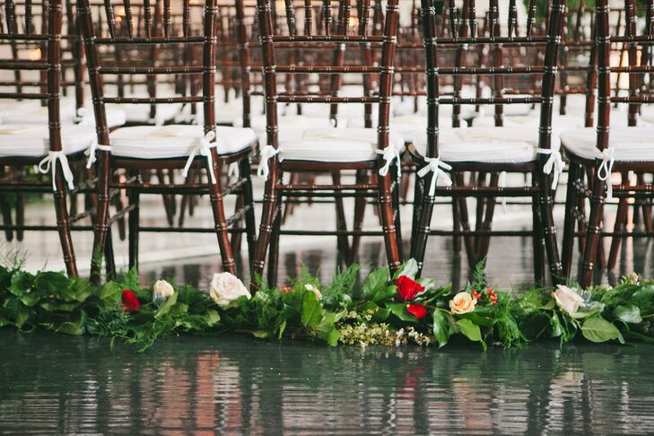 Wedding ceremony seating lined with green garland