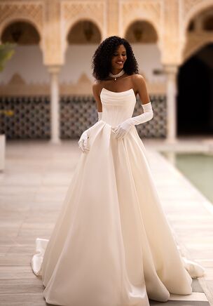 Introducing our glamorous A-line wedding dress, a vision of elegance and sophistication. Crafted from luxurious glossy fabric, it exudes a radiant glow that will leave a lasting impression. The strapless corset, beautifully draped and cinched to perfection, accentuates your feminine curves and adds a touch of timeless allure. The sweetheart neckline frames your décolletage with grace and romanticism, evoking a sense of ethereal beauty. This A-line wedding dress is a true celebration of style and individuality, designed to make you feel like a radiant bride on your special day.
